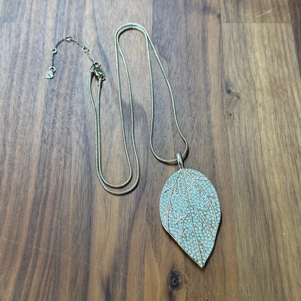 Aldo Gold Tone Clear Rhinestone Long Necklace with Leaf Feather Pendant